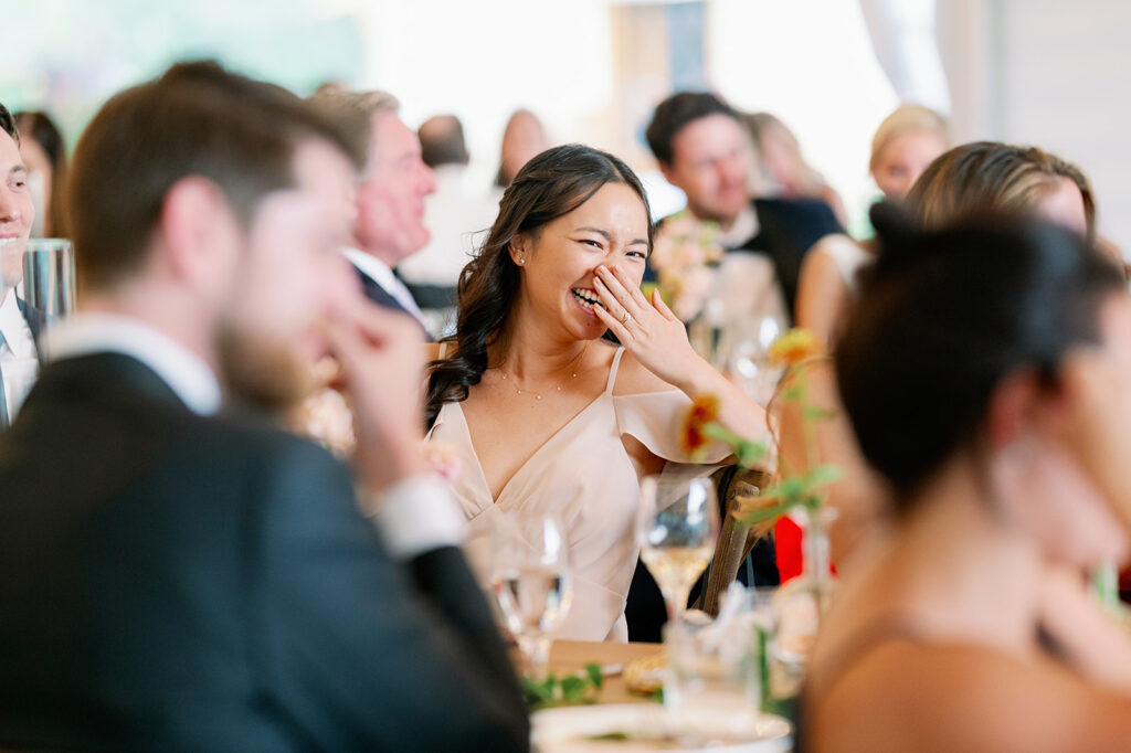 Guests laughing during reception dinner speeches.