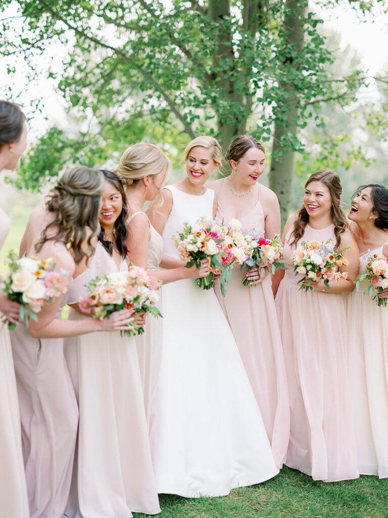 Neutral bridal party with pastel floral bouquets.