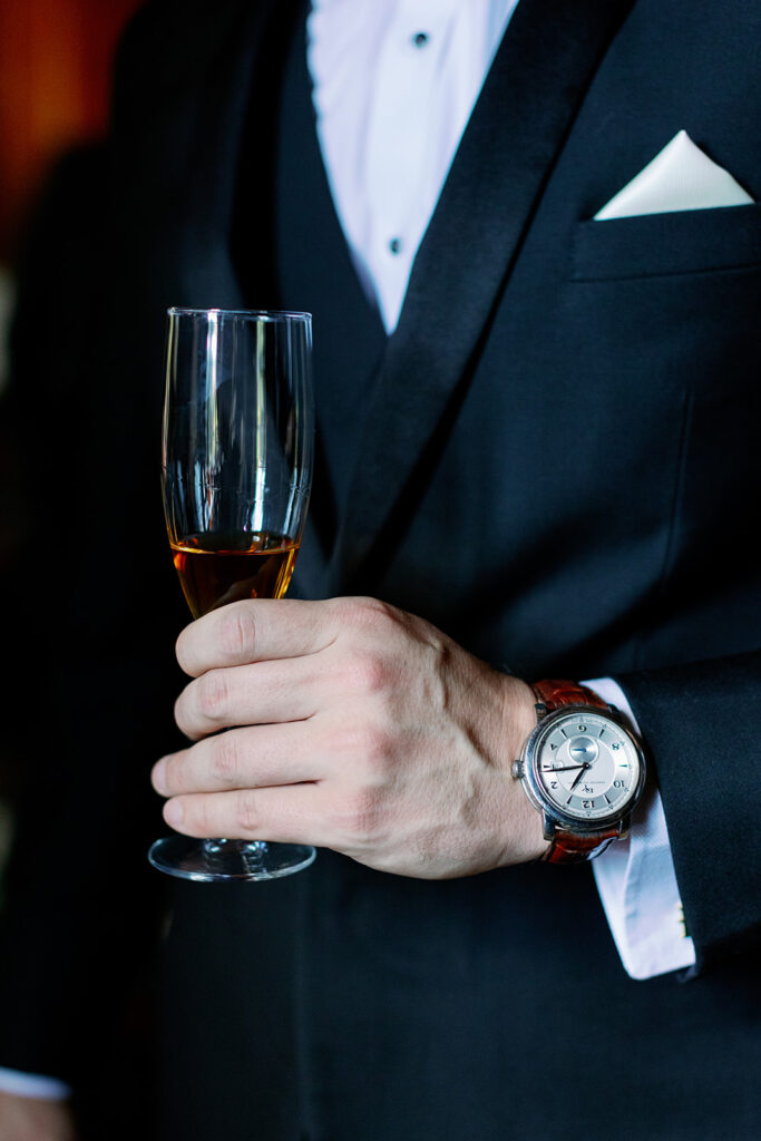 Groom holding a champagne glass.