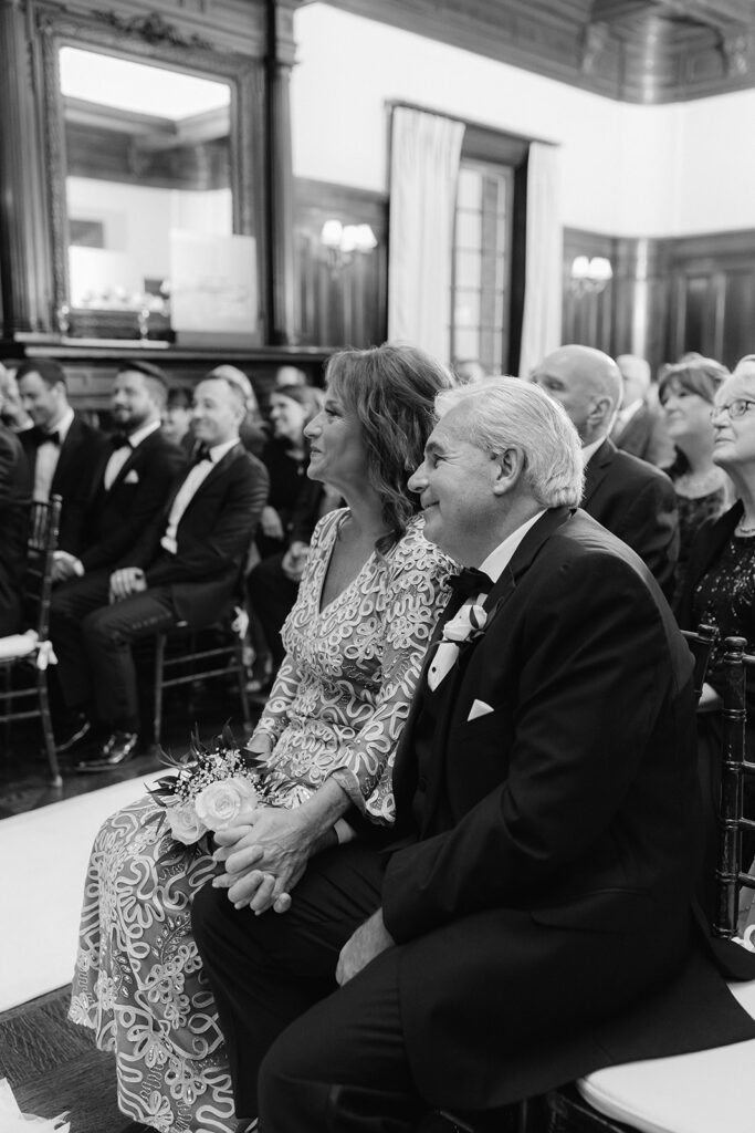 Candid moment of the groom's parents during the ceremony.