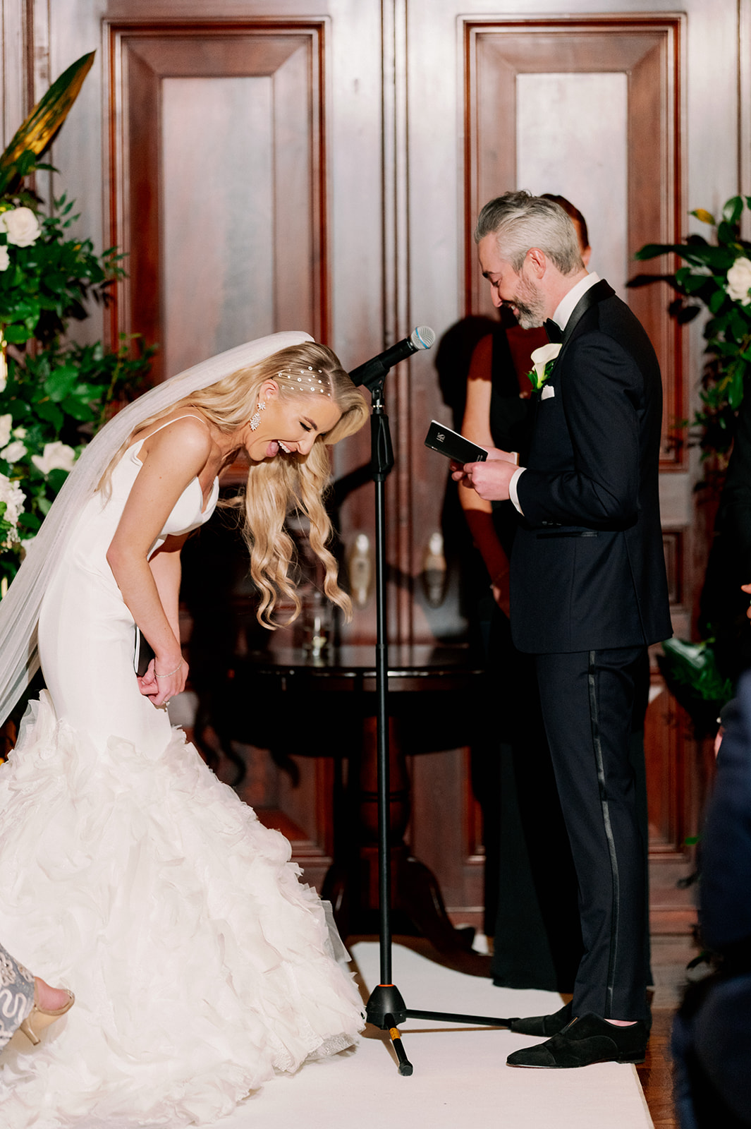Candid moment of bride and groom laughing during their wedding ceremony at Bourne Mansion.