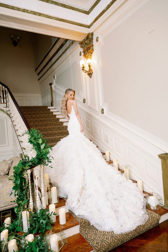 Bridal portrait on Bourne Mansion staircase with a long cathedral train. 