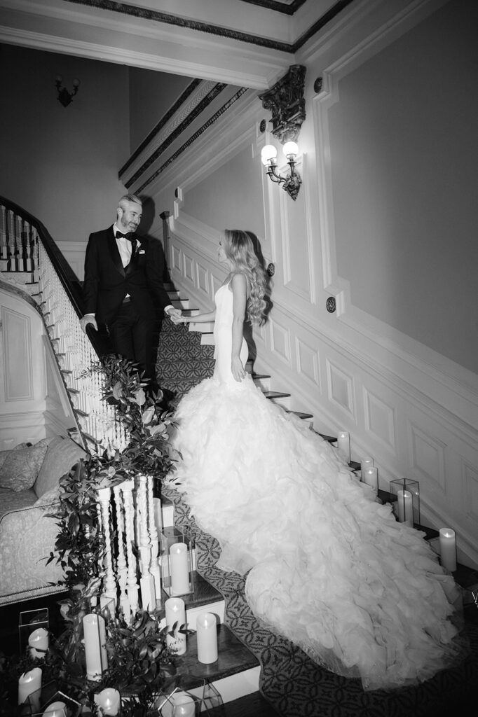 Bridal and groom portrait on Bourne Mansion staircase with a long cathedral train. 