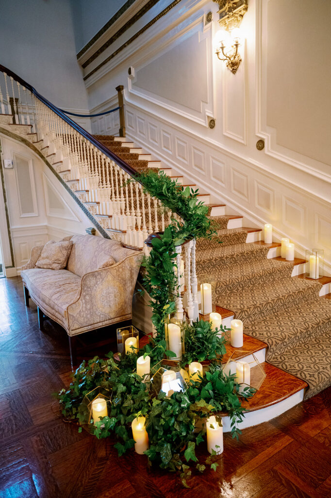 Bourne Mansion staircase decorated with greenery and candles.