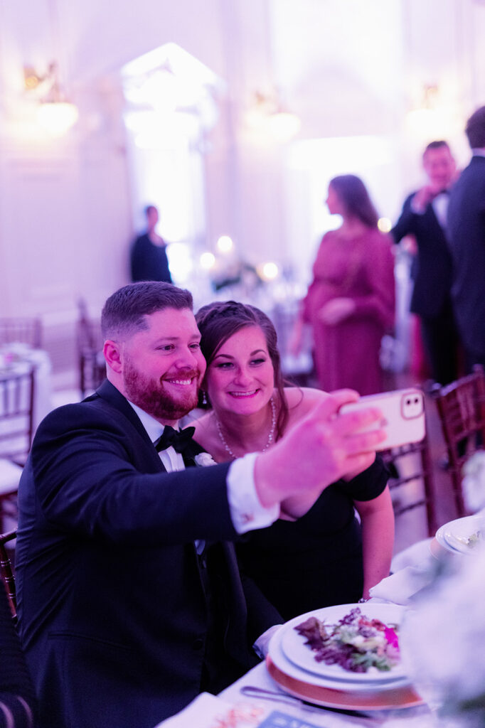 Wedding guests taking a selfie during dinner.