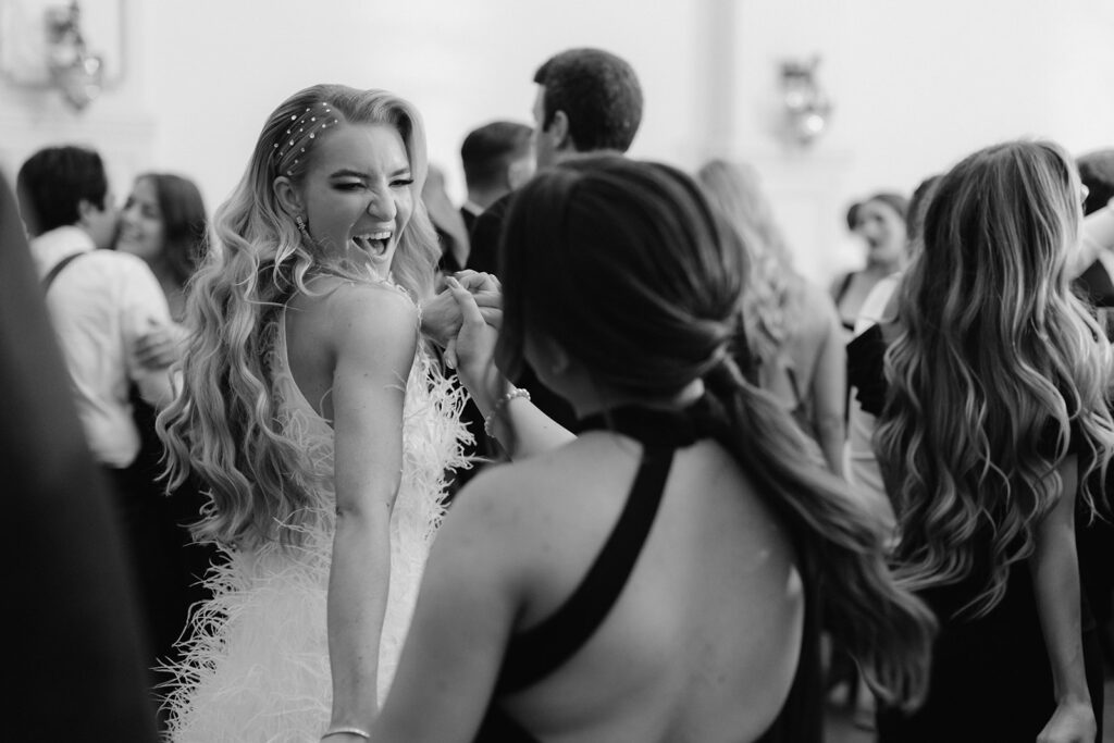 Candid moment of bride and bridesmaid after reception outfit change. 