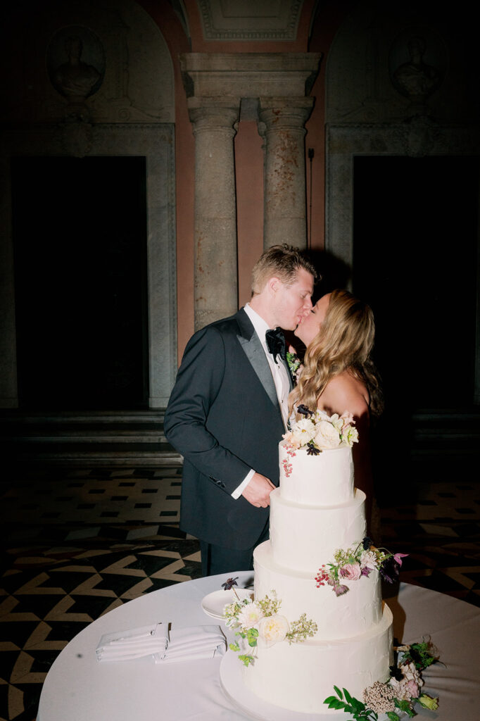 Bride and groom kissing after cake cutting.