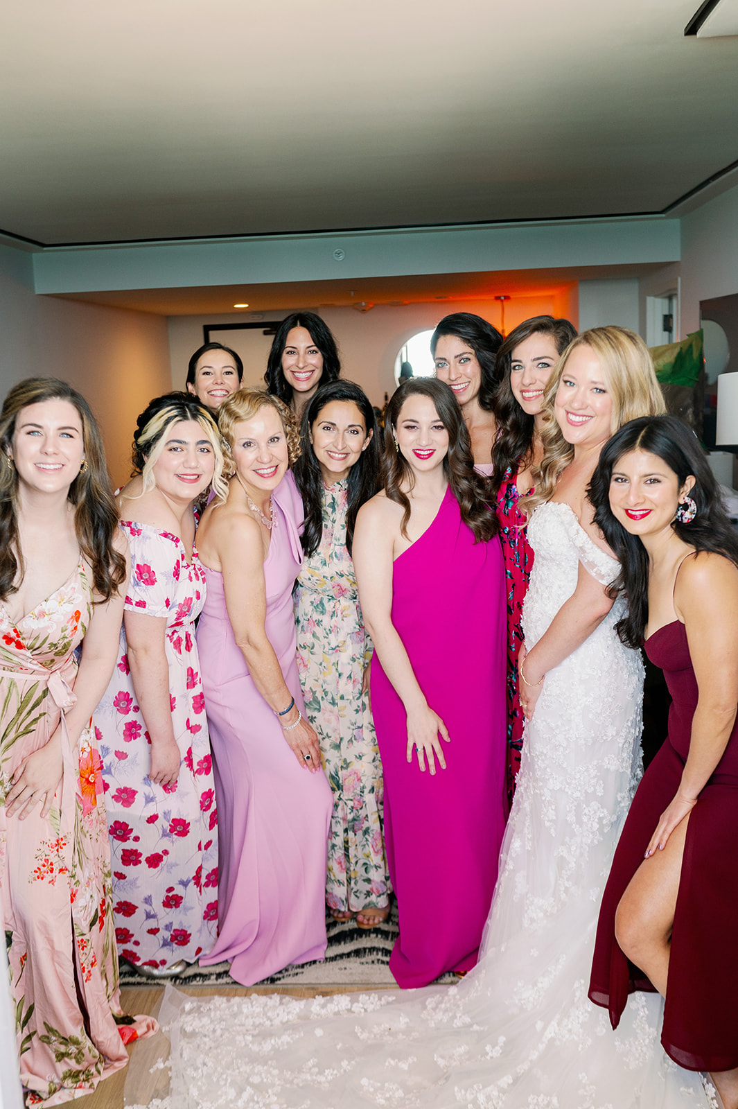 Bride and bridesmaids in mismatched pink dresses.