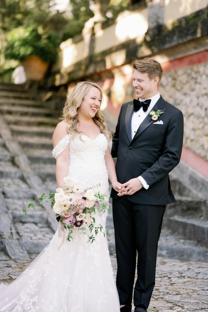 Candid bride and groom portrait in front of the stone stairs at Vizcaya Museum and Gardens.