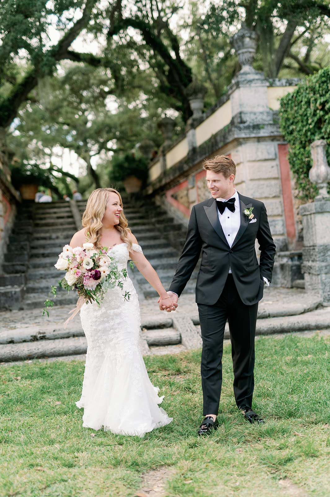 Bride and groom portrait in front of the stone stairs at Vizcaya Museum and Gardens.