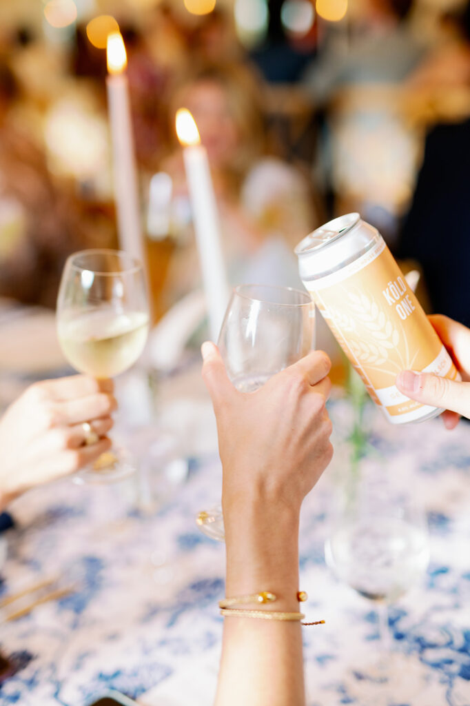 Guests clinking glasses at a wedding rehearsal dinner. 