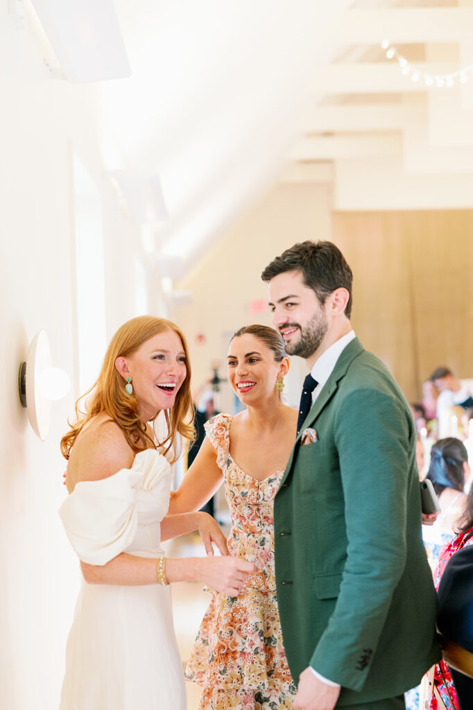 Candid moment between a bride and groom and a guest. 