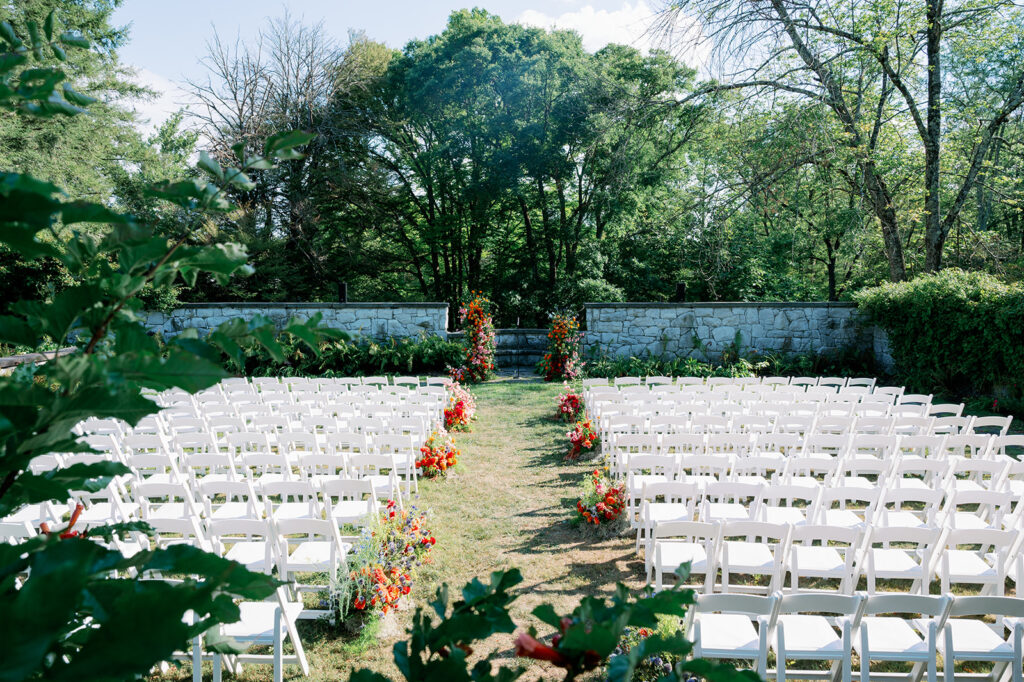 Outdoor wedding ceremony in The Walled Garden at Troutbeck with vibrant florals. 