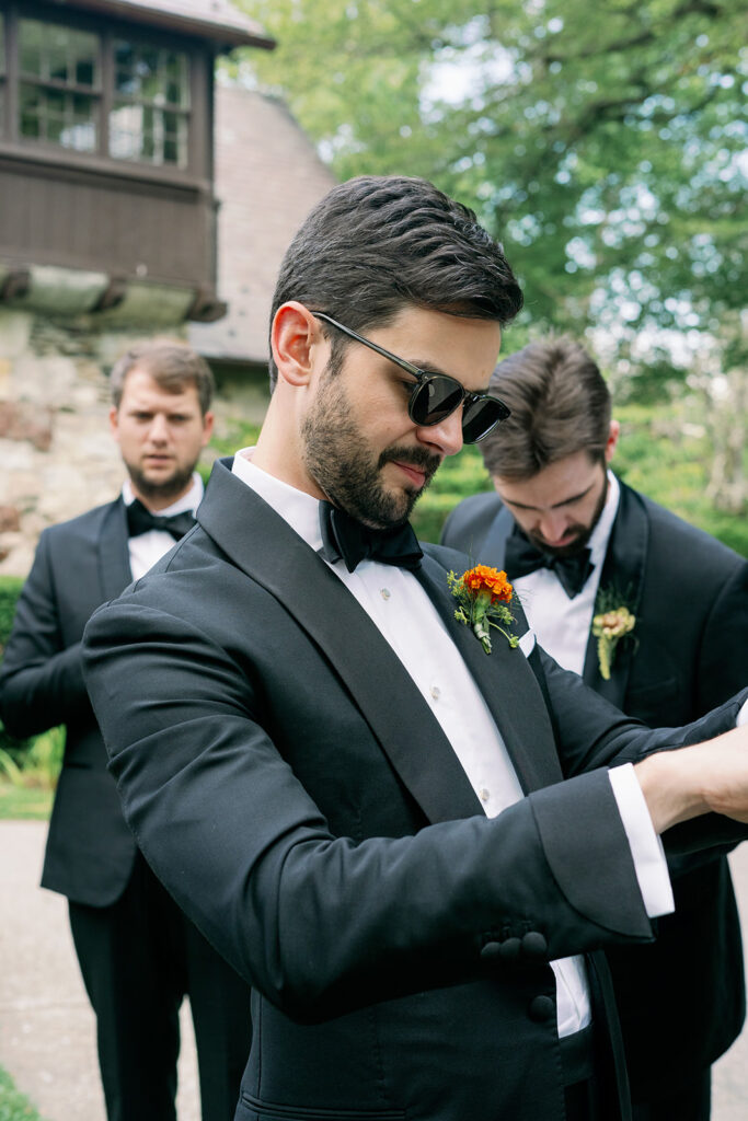 Candid summer wedding day photo of a groom wearing sunglasses. 
