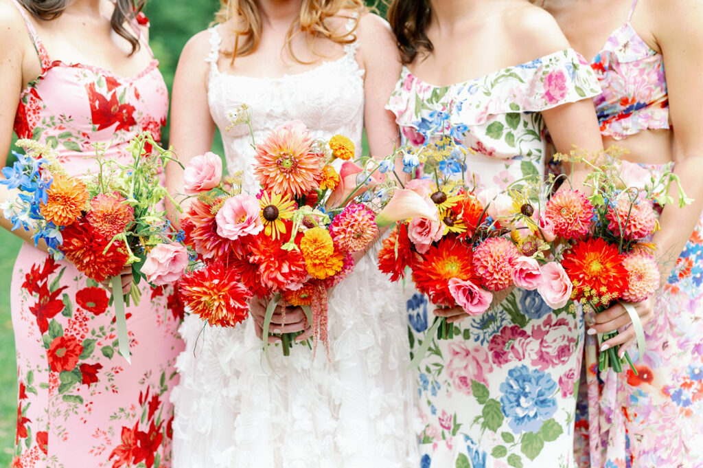 Vibrant summer wedding with floral bridesmaid dresses and colorful wildflower bouquets. 