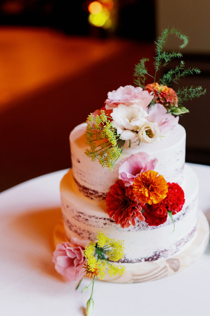 Naked cake with vibrant wildflowers.