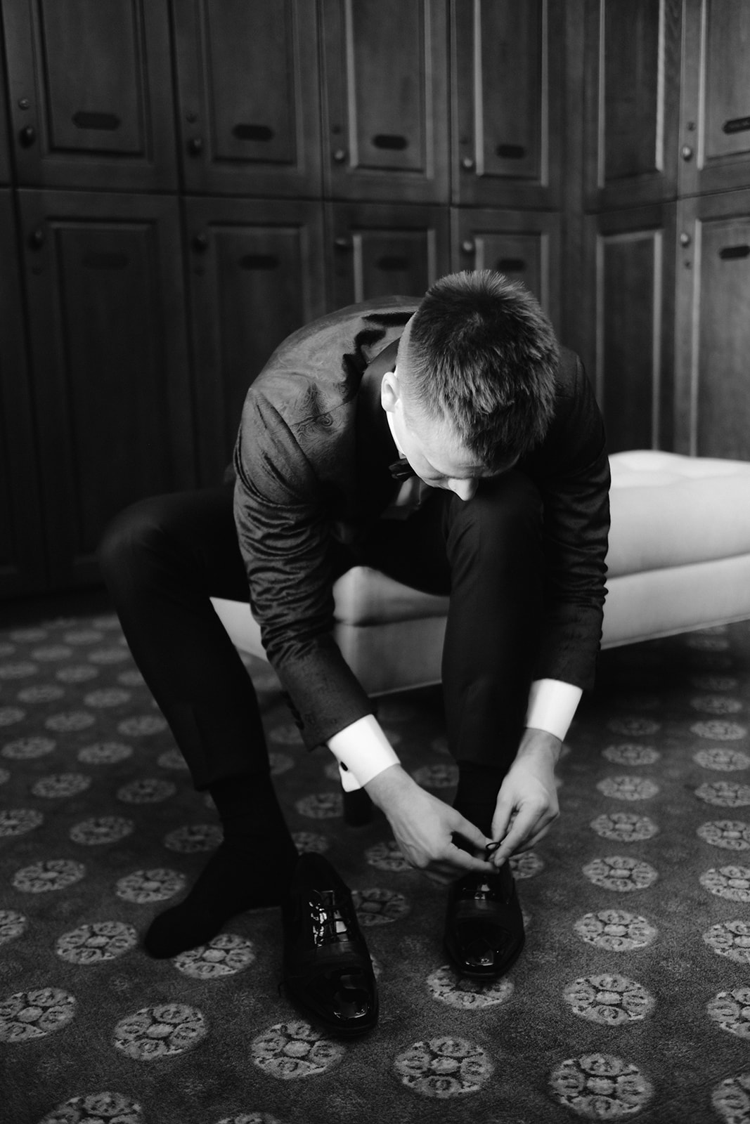 Groom getting ready tying his shoes.