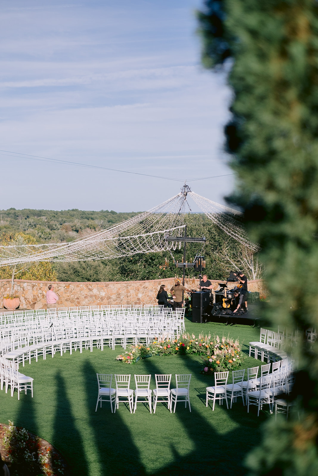 Bella Collina wedding ceremony with round seating and a canopy of fairy lights.