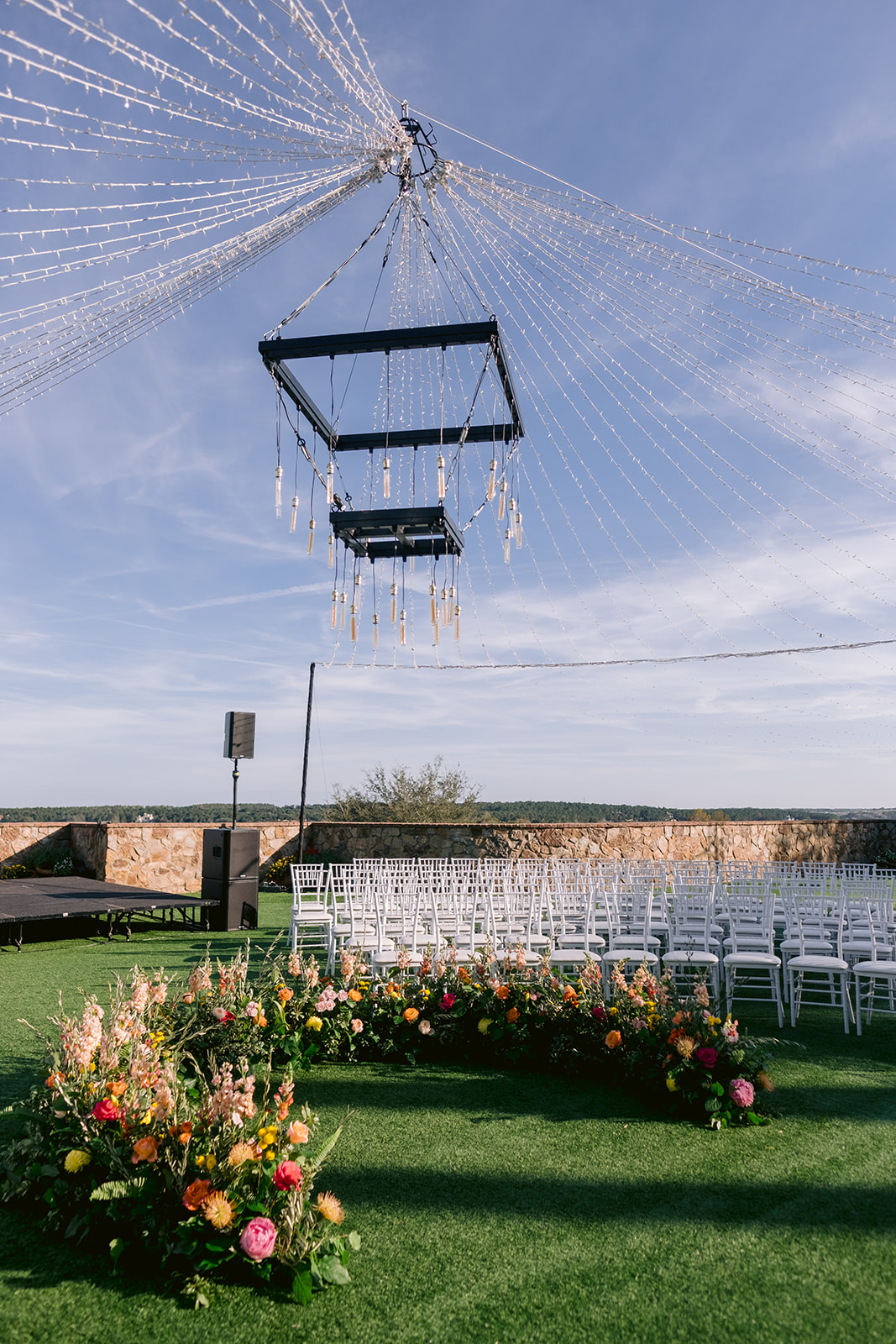 Vibrant floral wedding ceremony with round seating at Bella Collina.