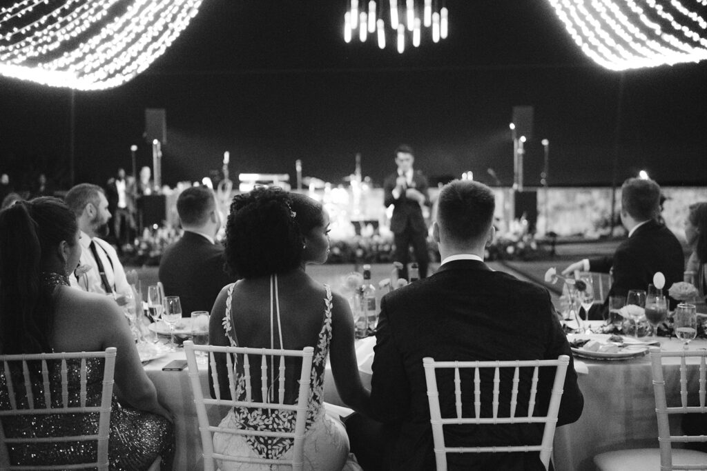 Candid moment of a bride and groom during speeches.