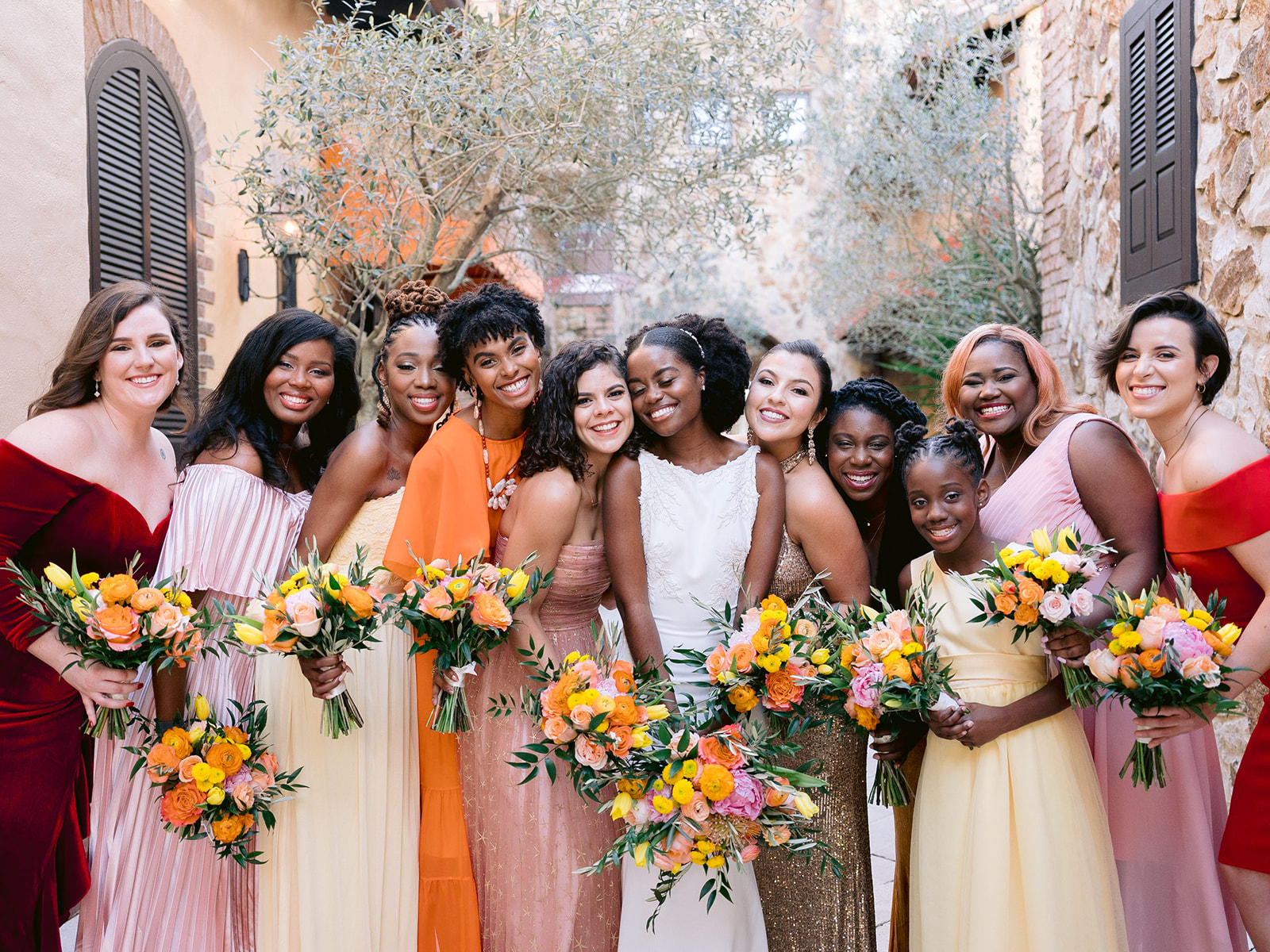 Bridal party portrait with mismatched dresses in a sunset color palette at Bella Collina.