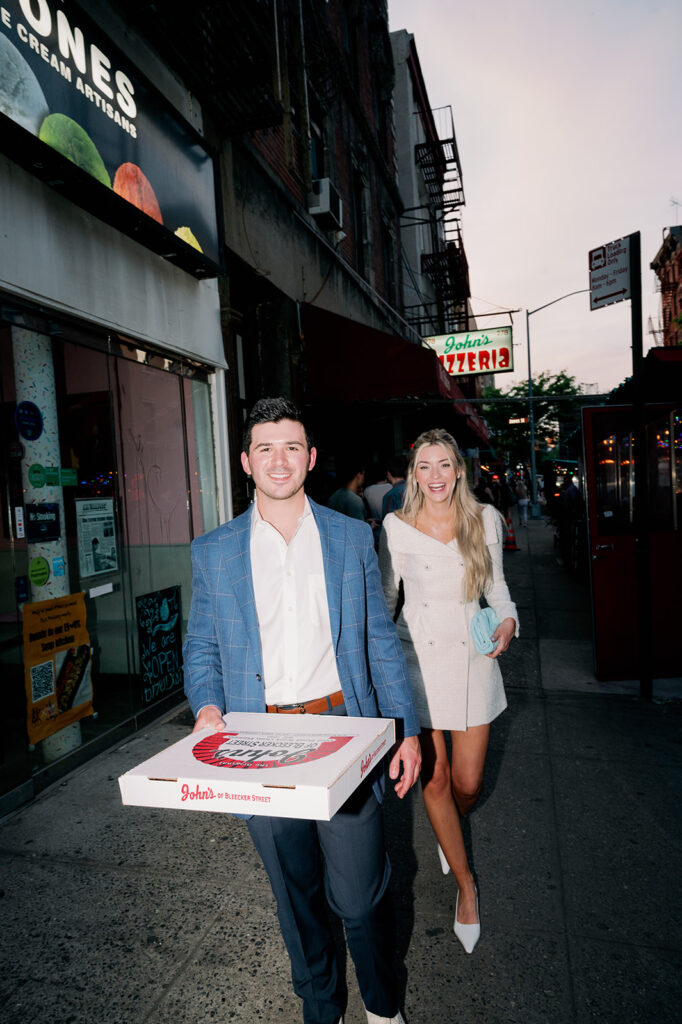 Couple ordering pizza from John's Pizzeria on Bleecker Street in New York City.