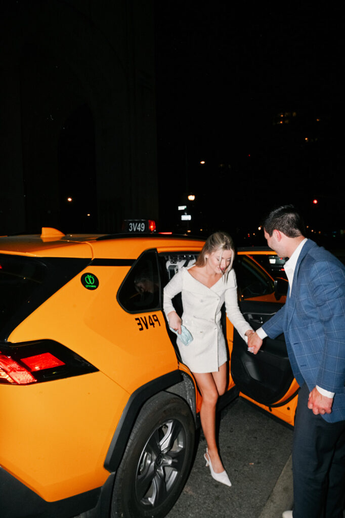 New York City couple getting out of a taxi during their romantic urban engagement session.