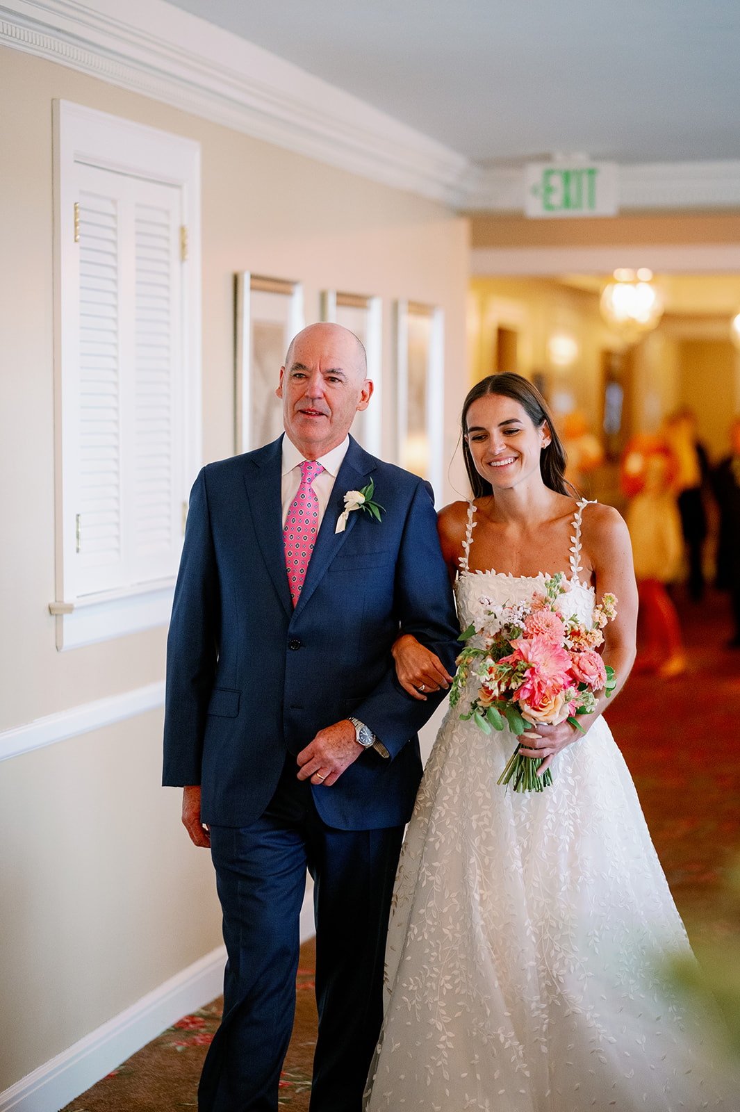 Carly linking arms with her dad getting ready to walk down the aisle.