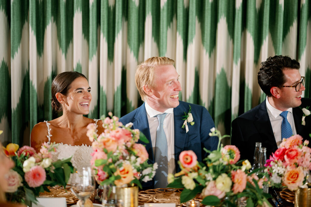 Bride and groom smiling while listening to speeches during their  Minikahda Club wedding dinner.