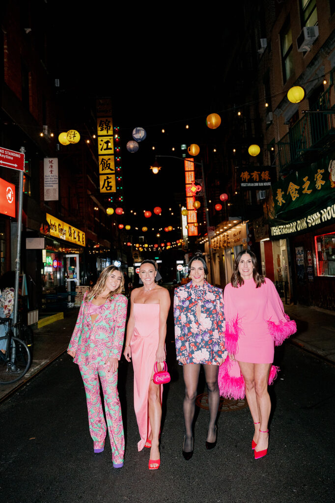 Nighttime bridal shower in Chinatown. Bride and sisters posing under city lights.