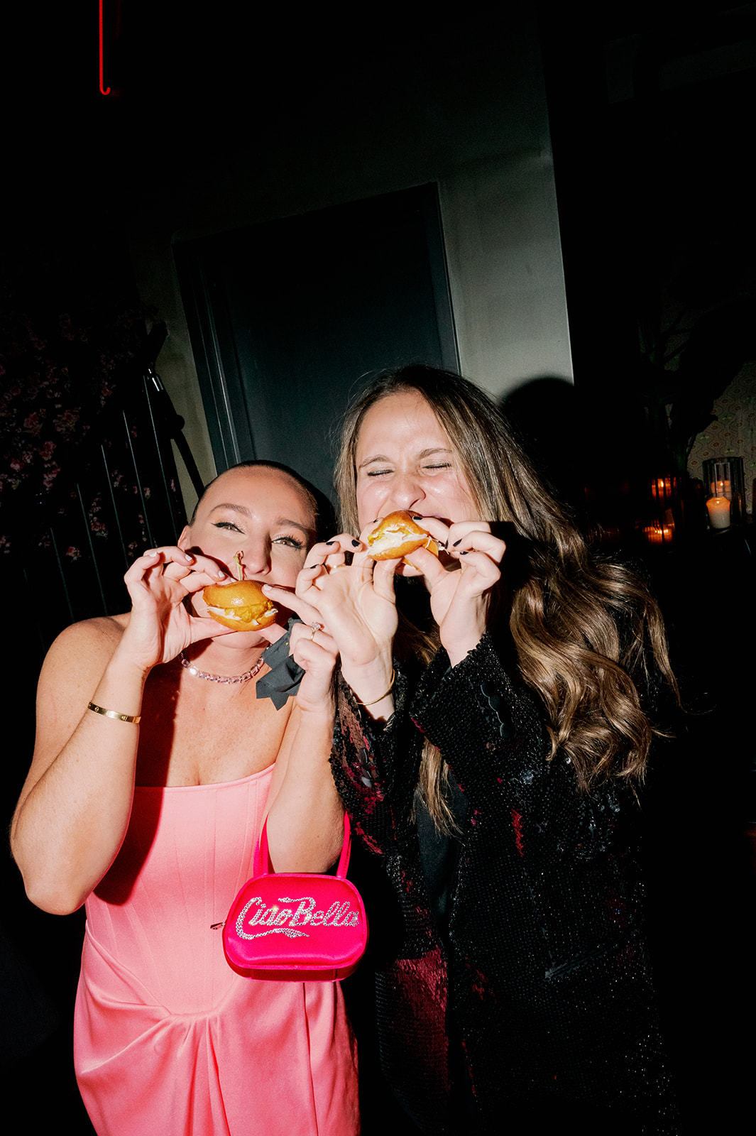 Bride and guest eating a slider. 