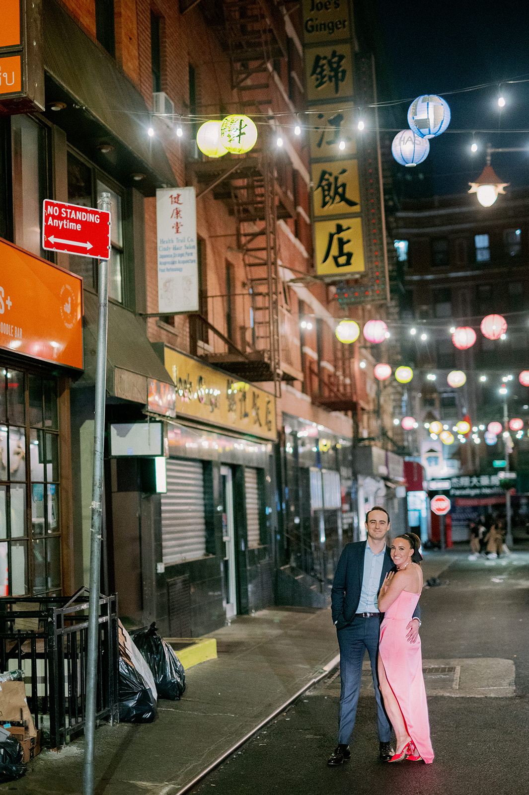 Couple wearing formal attire posing on a street in Chinatown, NYC.