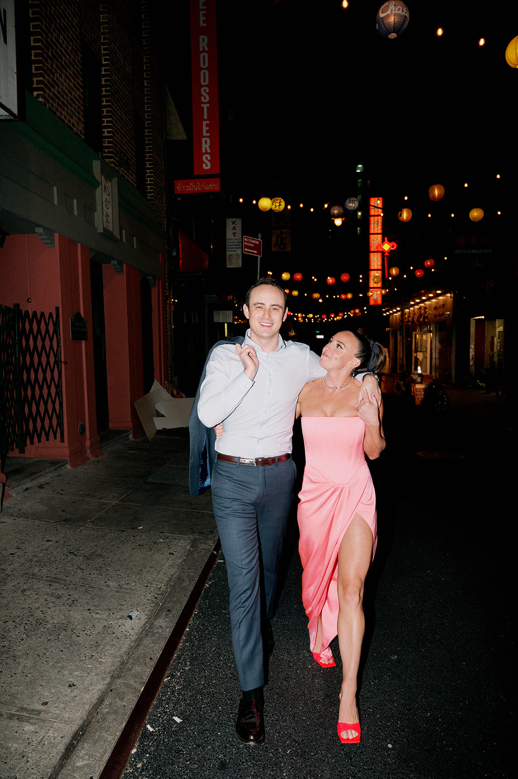 Nighttime flash photo of a couple walking in Chinatown.