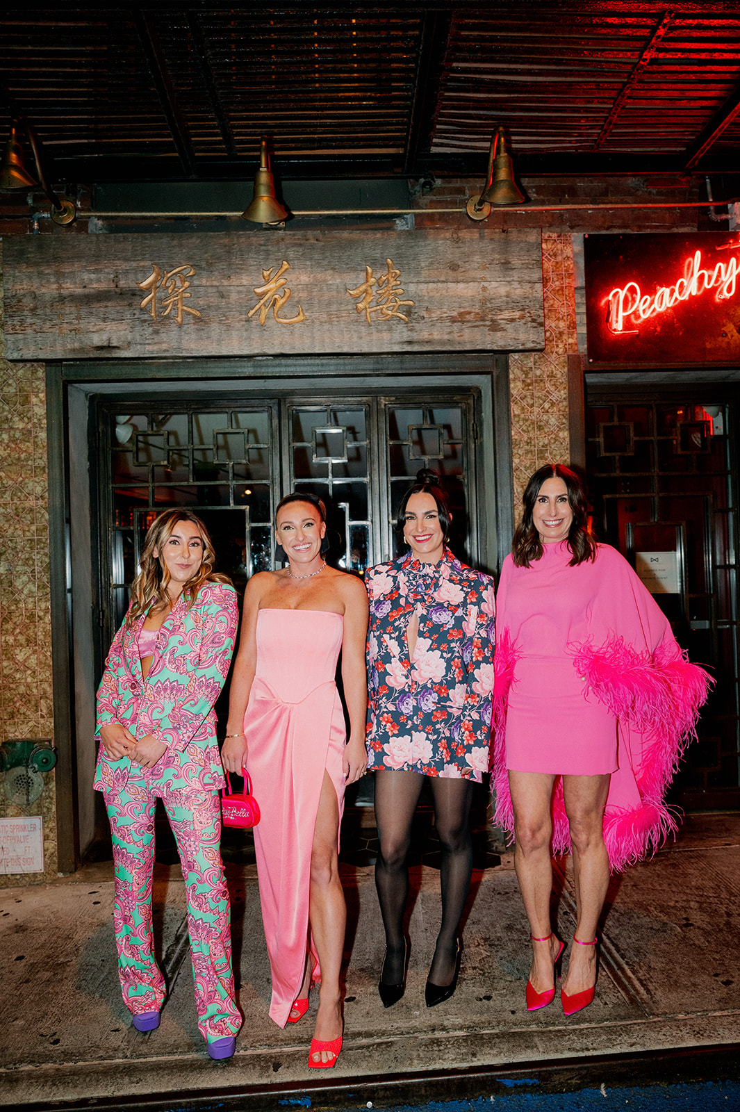 Caroline Keogh and sister's pose outside Peachy's bar for a fun, neon Chinatown bridal shower.