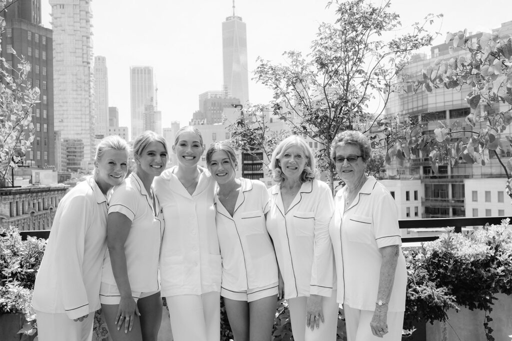Bride, bridesmaids, mom, mother-in-law, and grandma, all in pajamas, create a black-and-white portrait on a New York wedding morning.
