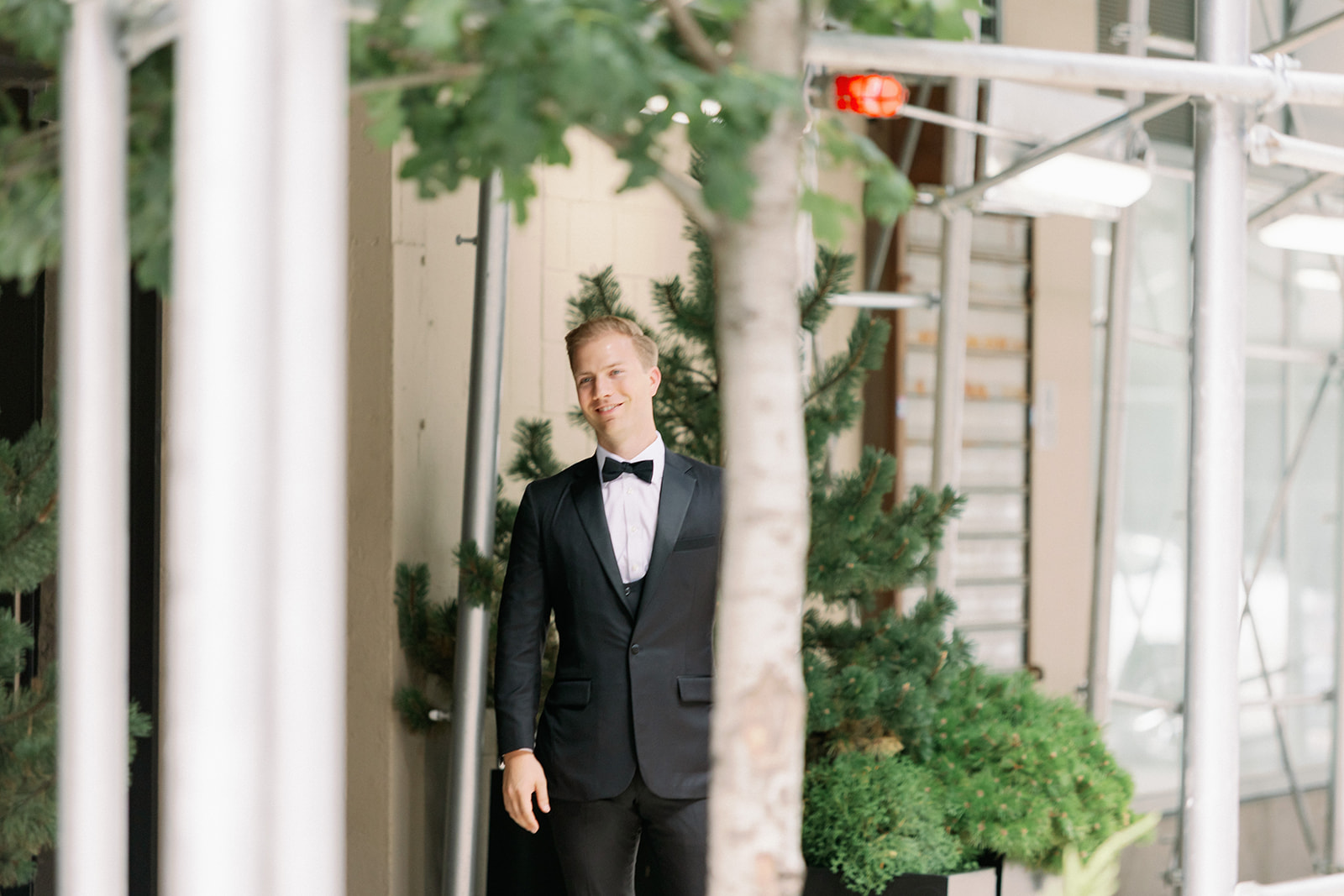 Emotional first look: Groom framed by greenery and scaffolding smiles seeing his bride at Tribeca Rooftop, a stunning New York wedding moment.