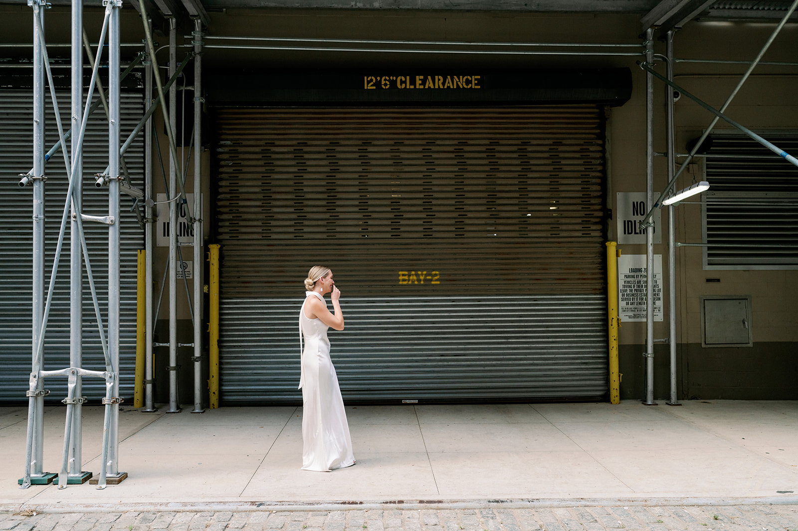 Bride walks towards groom, smiling and hand to mouth, outside Tribeca Rooftop, in a magical New York wedding first look.