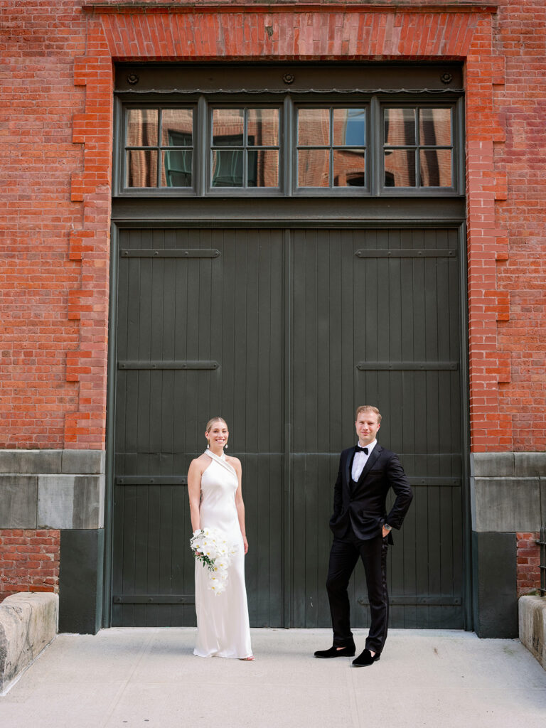 West Village bride and groom portrait framed by a large black door, a timeless New York wedding moment.