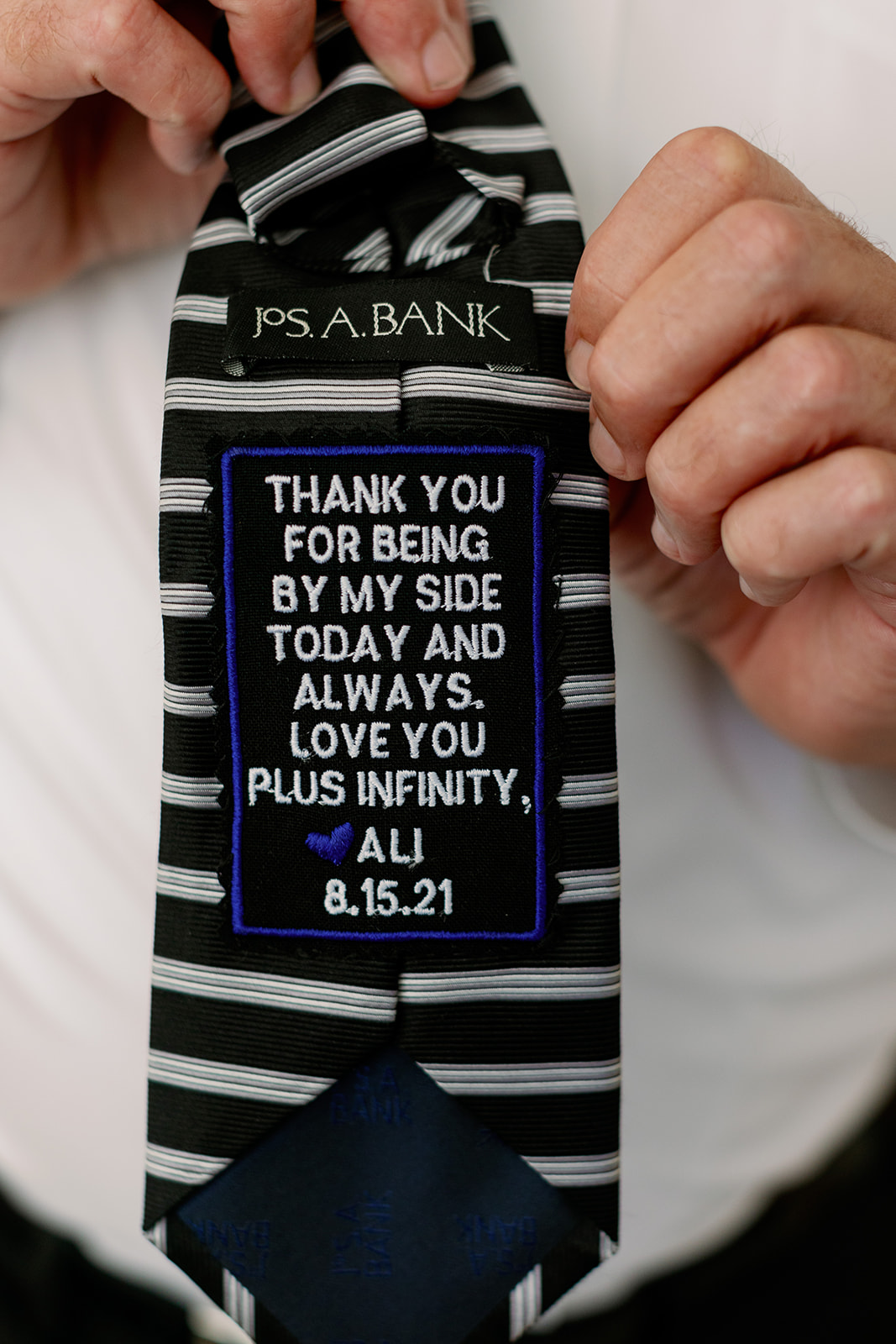 Close-up of the bride's dad's custom tie with a heartfelt message, a beautiful detail on this New York wedding day.