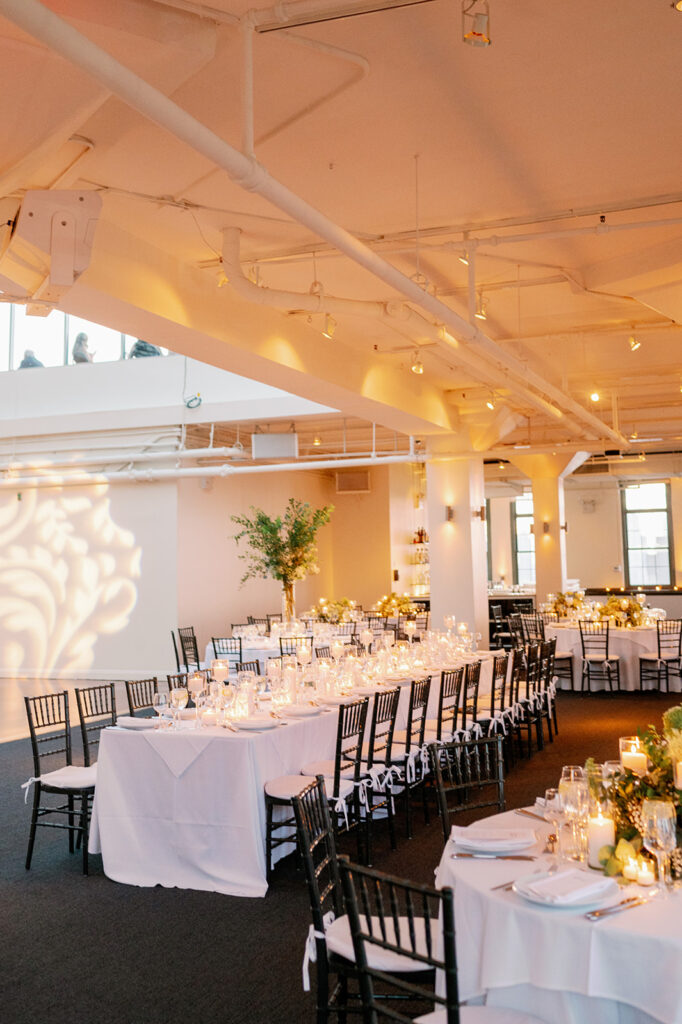 Tribeca Rooftop wedding reception tables adorned with elegant white and black decor, complemented by lush greenery.