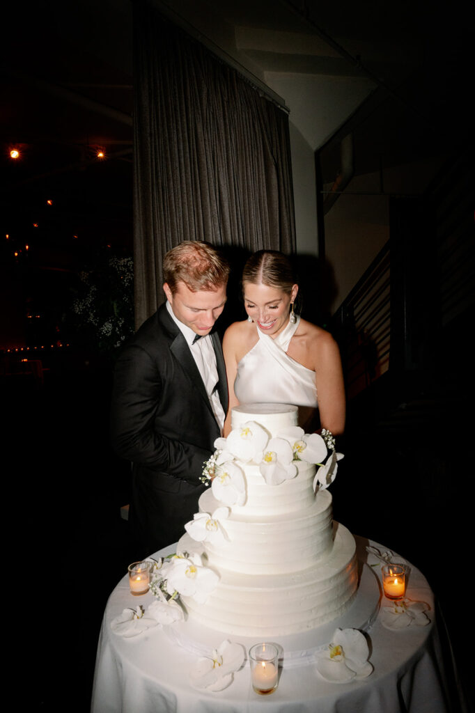 Tribeca Rooftop wedding reception - Candid and direct flash capture of the bride and groom cutting the cake.