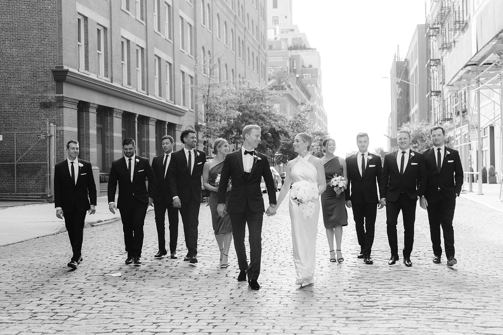 West Village bride, groom, and wedding party walk together in a candid New York wedding portrait.