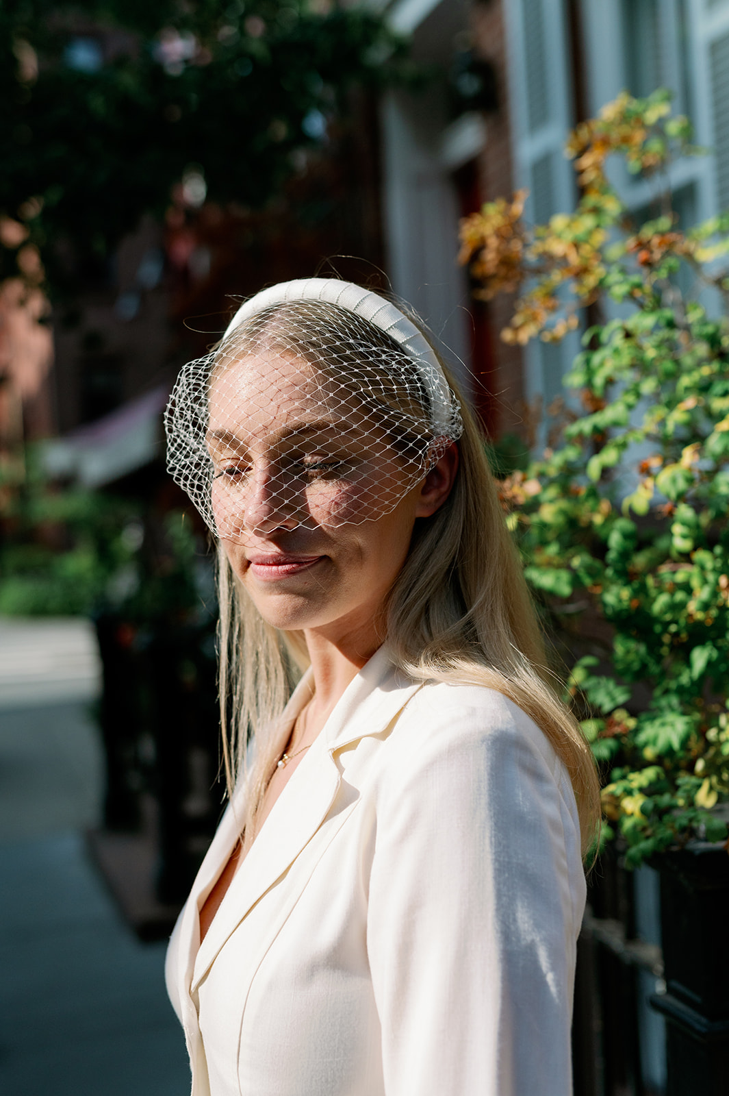 Bride in West Village dons vintage suit dress and cloche veil, embodying timeless New York elegance.