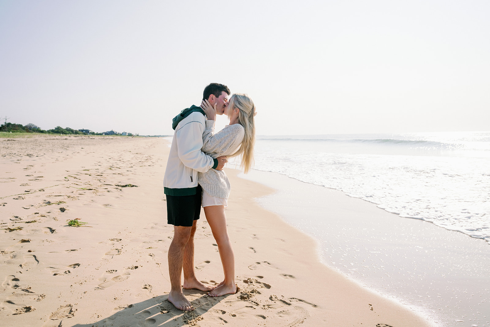 Couple kissing on the beach in Westerly Rhode Island before their wedding at Ocean House. 