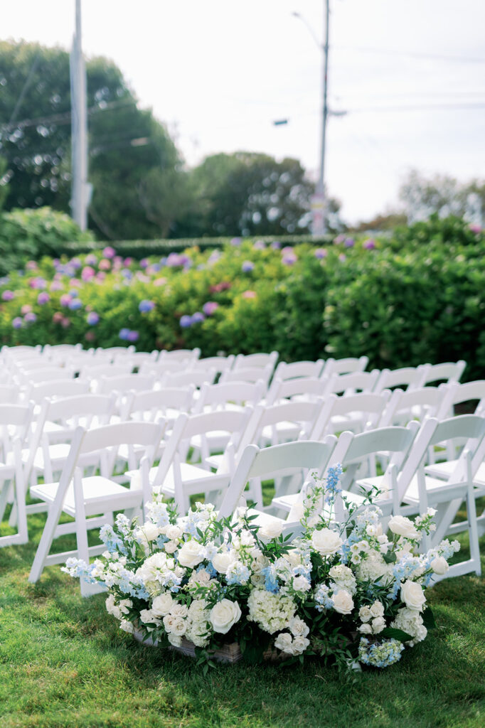 Outdoor wedding ceremony seating at Ocean House with white and blue hydrangea floral arrangements. 