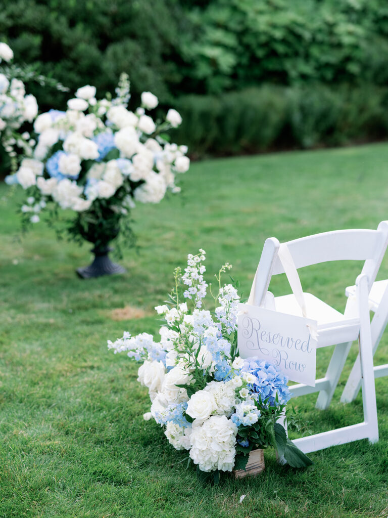 White and blue hydrangea wedding ceremony aisle floral arrangements. 