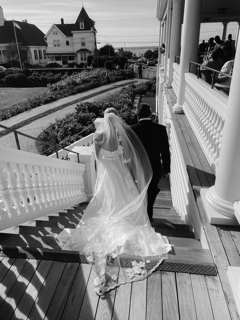 Bride walking down the steps of Ocean House toward the South Lawn ceremony overlooking the ocean. 