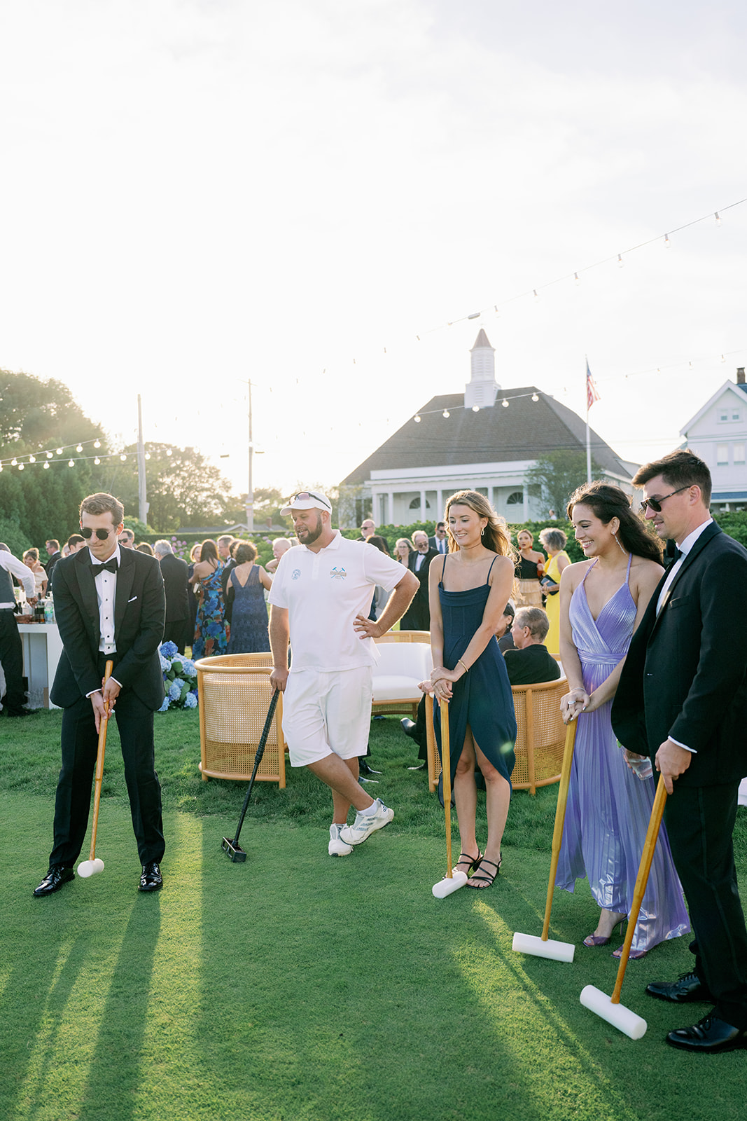 Wedding guests getting instructions from a croquet professional at an Ocean House cocktail hour.