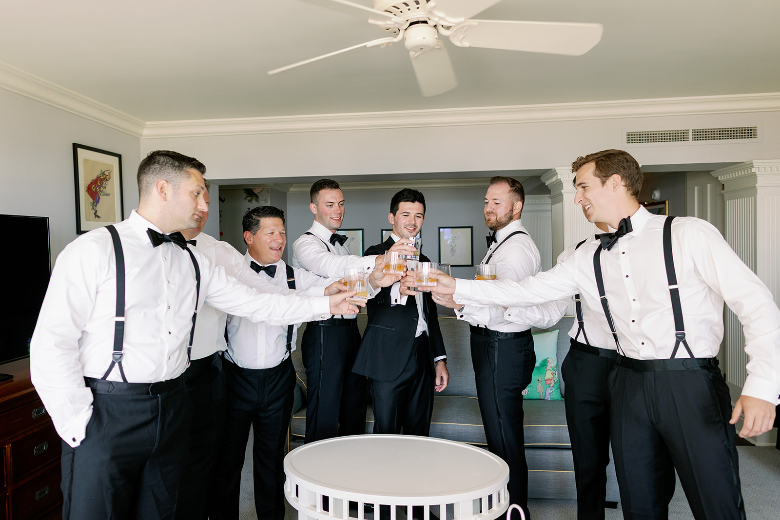 Groom and groomsmen toasting in a Ocean House hotel room. 
