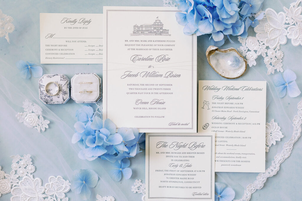 White and blue classic Ocean House wedding invitation flat lay. 